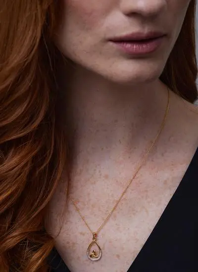 Close up shot of red haired model wearing 14Ct Gold Vermeil Trinity Knot Tear Drop Pendant